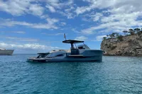 2022 Solaris Power 44 Open yacht on clear blue water near rocky coastline.