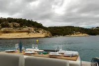 Luxurious dining setup on Solaris Power 44 Open yacht, 2022, with scenic coastal view.