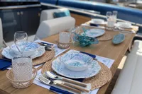 Elegant dining setup on 2022 Solaris Power 44 Open yacht, featuring nautical-themed tableware.