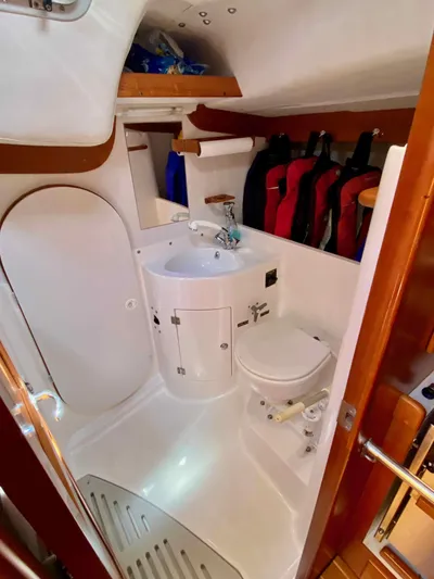 Navicula Yacht Photos Pics 2001 J Boats J/46 yacht bathroom with sink, toilet, and hanging jackets.