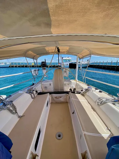 Navicula Yacht Photos Pics 2001 J Boats J/46 sailboat cockpit with canopy, docked by clear blue water.