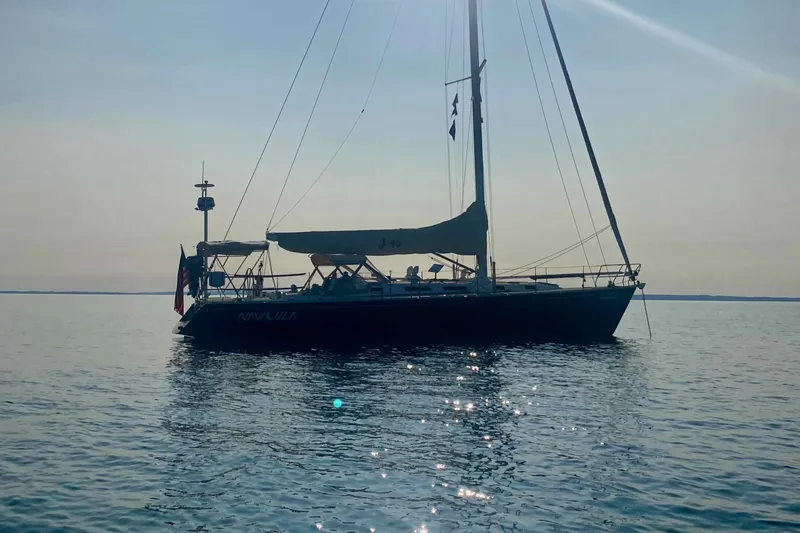 Navicula Yacht Photos Pics 2001 J Boats J/46 sailboat on calm water at sunset.