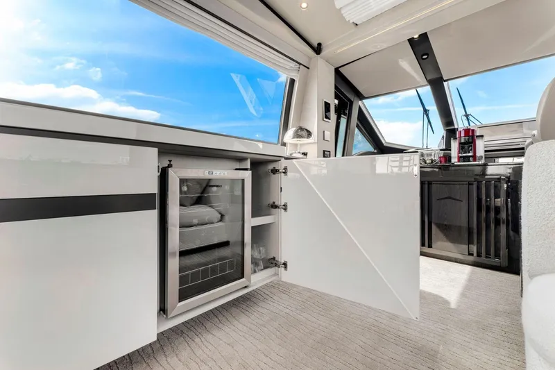 Latitude Yacht Photos Pics Luxurious interior of 2022 Azimut S10 yacht with open cabinet and mini fridge.