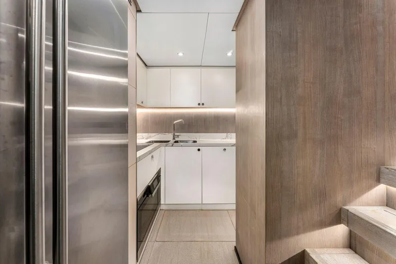 Latitude Yacht Photos Pics Modern kitchen interior on 2022 Azimut S10 yacht, featuring sleek cabinetry and stainless steel appliances.