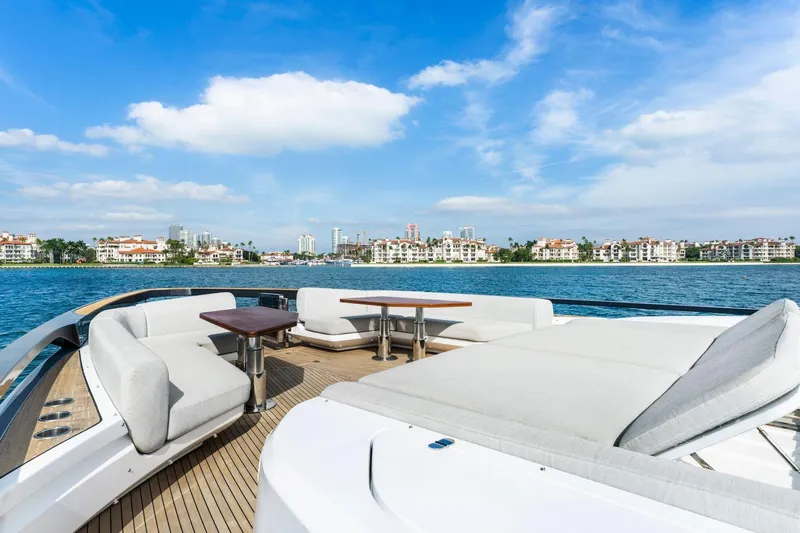 Latitude Yacht Photos Pics Luxurious 2022 Azimut S10 yacht deck with elegant seating, overlooking coastal skyline.