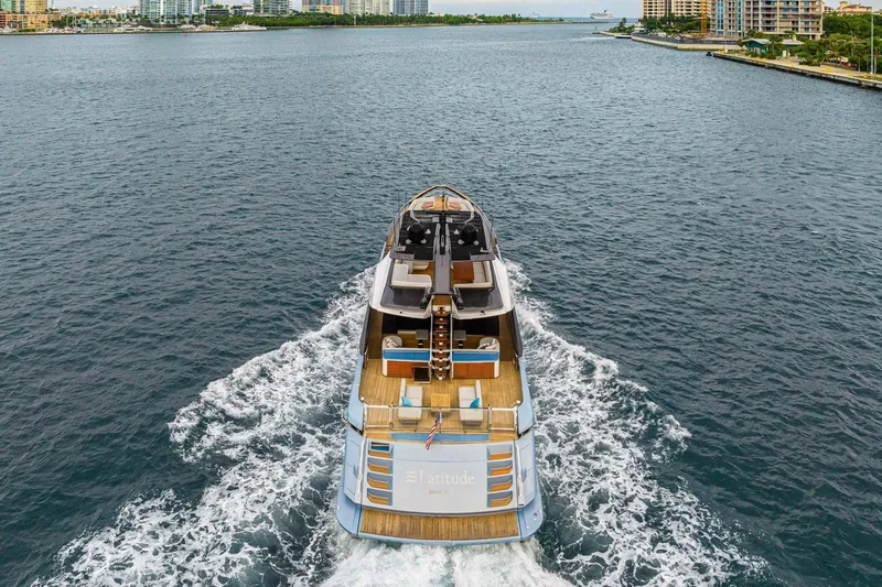 Latitude Yacht Photos Pics Azimut S10 2022 luxury yacht cruising in open water, city skyline in background.