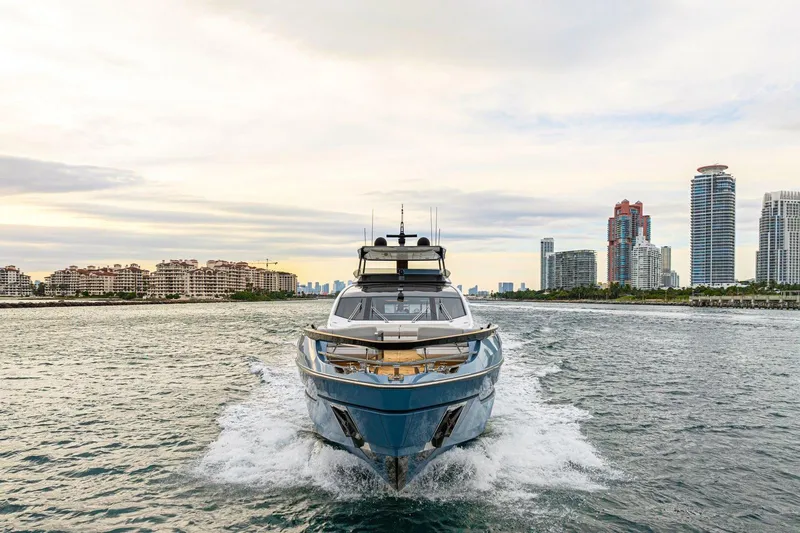 Latitude Yacht Photos Pics 2022 Azimut S10 yacht cruising near city skyline at sunset.