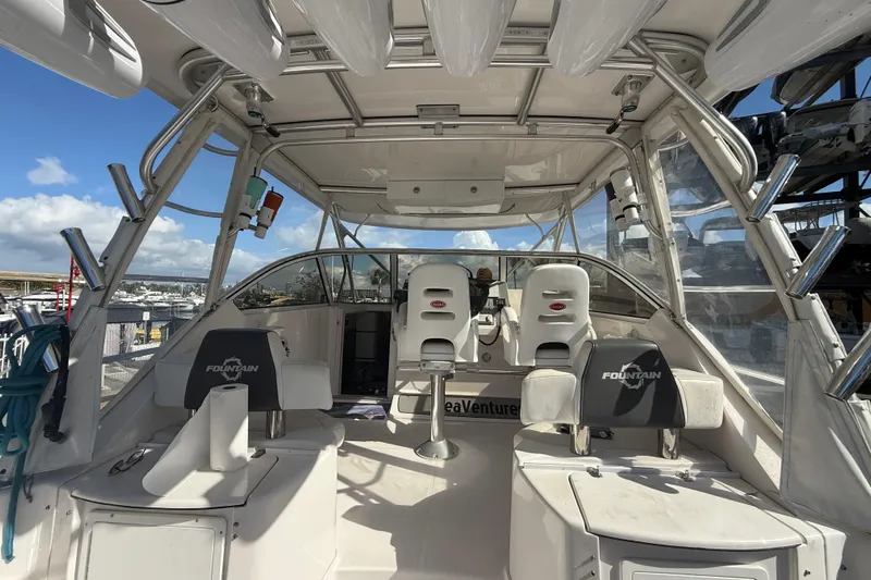  Yacht Photos Pics 2017 Fountain 38 Sportfish Cruiser interior with seating and helm, docked under sunny skies.