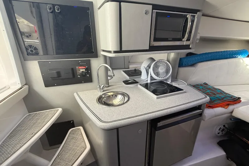  Yacht Photos Pics 2017 Fountain 38 Sportfish Cruiser interior with kitchenette, featuring sink, stove, and microwave.