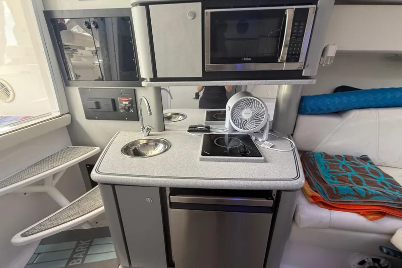  Yacht Photos Pics Compact kitchen area in 2017 Fountain 38 Sportfish Cruiser with sink, stove, and microwave.