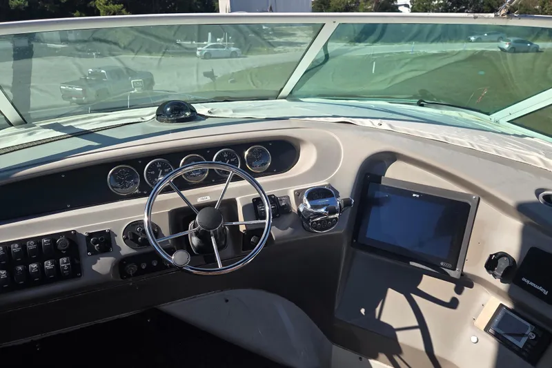 Pier Pressure Yacht Photos Pics Pilothouse interior of 2000 Carver 450 Voyager with steering wheel and navigation controls.