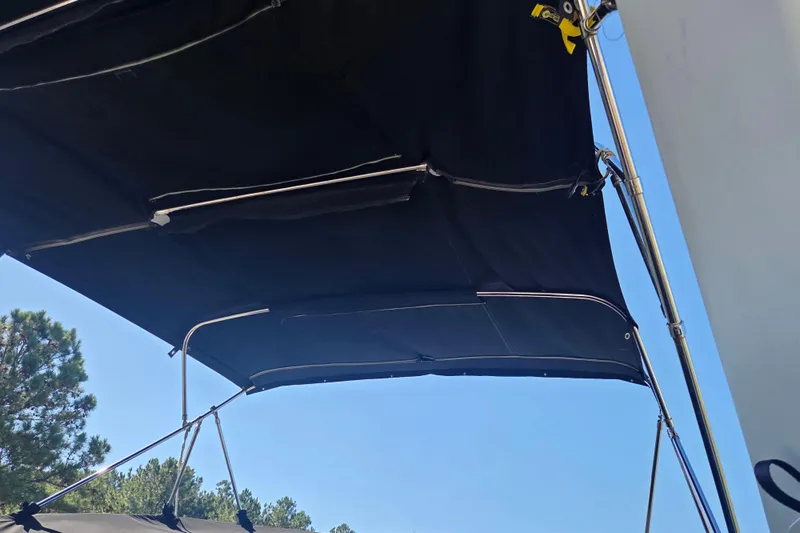 Pier Pressure Yacht Photos Pics Black canopy on 2000 Carver 450 Voyager Pilothouse against blue sky.