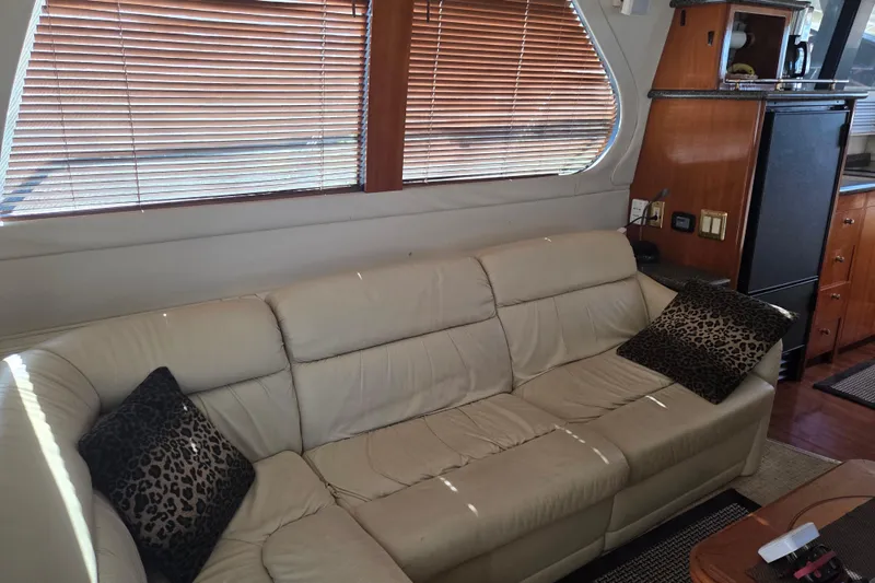 Pier Pressure Yacht Photos Pics Interior of 2000 Carver 450 Voyager Pilothouse with beige sofa and leopard print pillows.
