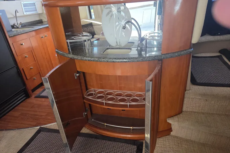 Pier Pressure Yacht Photos Pics Interior of 2000 Carver 450 Voyager Pilothouse with open cabinet and decorative vase.