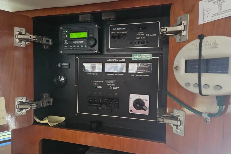 Pier Pressure Yacht Photos Pics Electrical control panel inside 2000 Carver 450 Voyager Pilothouse boat, featuring generator and AC system controls.