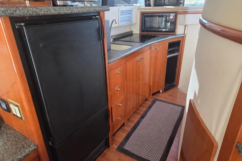 Pier Pressure Yacht Photos Pics Kitchen area of 2000 Carver 450 Voyager Pilothouse with wood cabinetry and appliances.