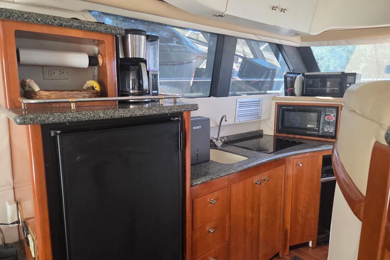 Pier Pressure Yacht Photos Pics Interior of 2000 Carver 450 Voyager Pilothouse with kitchen amenities and wooden cabinetry.