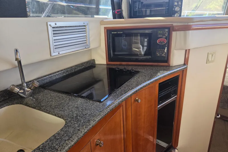 Pier Pressure Yacht Photos Pics Kitchen area of 2000 Carver 450 Voyager Pilothouse with microwave and stovetop.