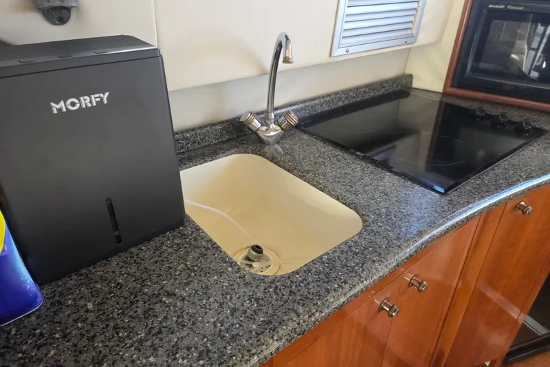 Pier Pressure Yacht Photos Pics Kitchen area of 2000 Carver 450 Voyager Pilothouse with sink and stove.