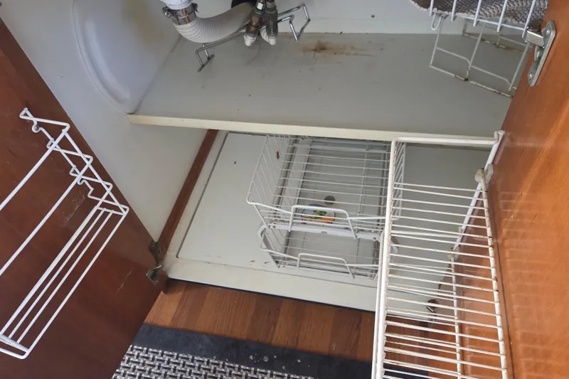 Pier Pressure Yacht Photos Pics Open cabinet with wire racks and plumbing, Carver 450 Voyager Pilothouse, 2000 model.