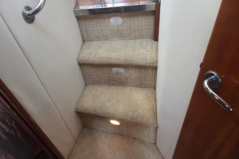 Pier Pressure Yacht Photos Pics Carpeted stairs inside 2000 Carver 450 Voyager Pilothouse with handrail and lighting.