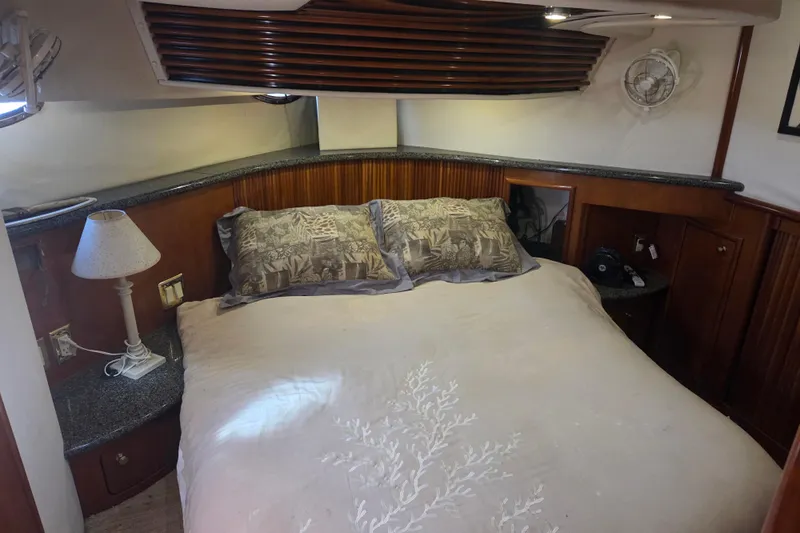 Pier Pressure Yacht Photos Pics Cozy bedroom in 2000 Carver 450 Voyager Pilothouse with elegant bedding and wooden accents.