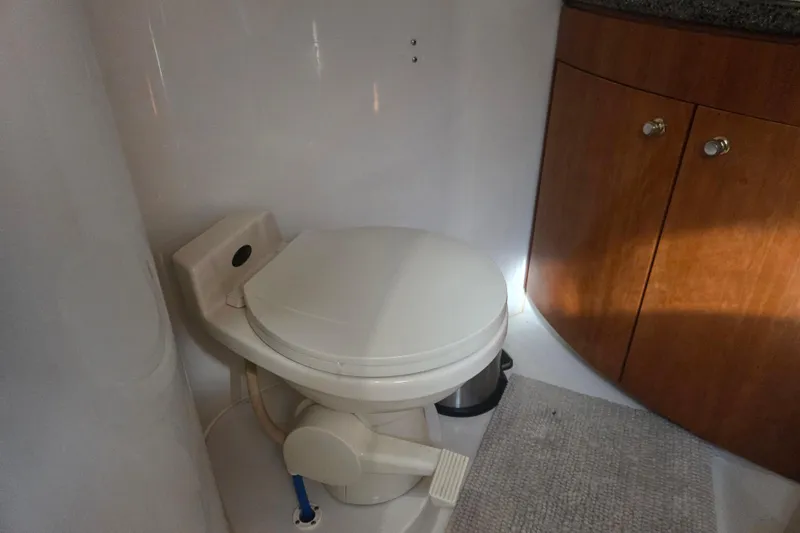 Pier Pressure Yacht Photos Pics Bathroom interior of 2000 Carver 450 Voyager Pilothouse with toilet and wooden cabinet.