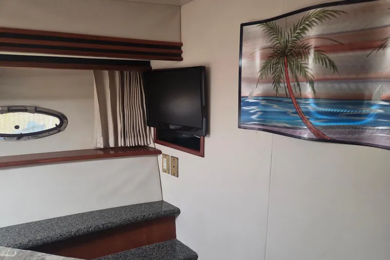 Pier Pressure Yacht Photos Pics Interior of 2000 Carver 450 Voyager Pilothouse with TV and tropical wall art.