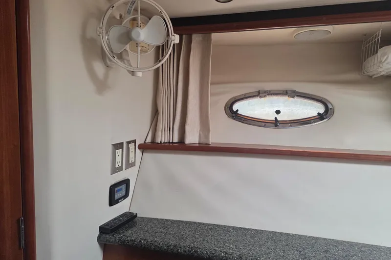 Pier Pressure Yacht Photos Pics Interior of 2000 Carver 450 Voyager Pilothouse with fan, porthole, and granite countertop.