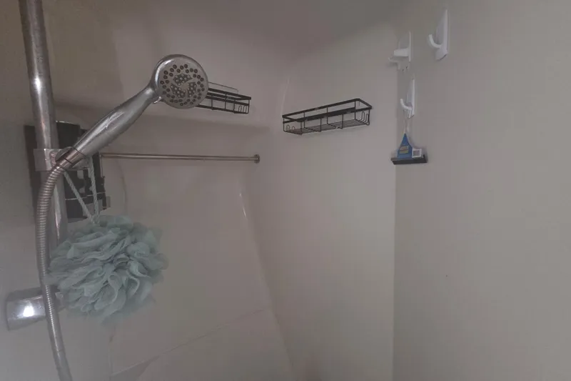 Pier Pressure Yacht Photos Pics Shower area in a 2000 Carver 450 Voyager Pilothouse with handheld showerhead and storage racks.