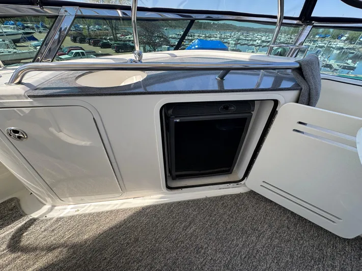 Current Affair Yacht Photos Pics 2005 Sea Ray 500 Sedan Bridge yacht interior with open cabinet and mini fridge.