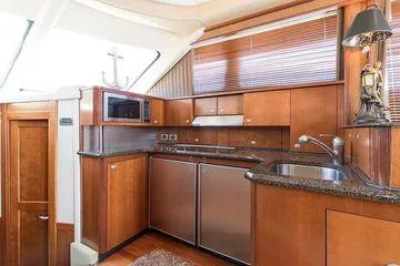 Current Affair Yacht Photos Pics Luxurious kitchen interior of 2005 Sea Ray 500 Sedan Bridge yacht with wood cabinetry.