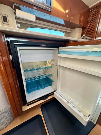 Pendragon Yacht Photos Pics 2009 Sea Ray 350 Sundancer interior with open refrigerator, showcasing modern kitchen amenities.