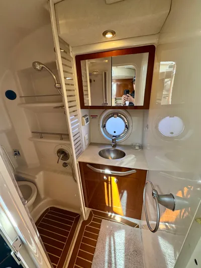 Pendragon Yacht Photos Pics 2009 Sea Ray 350 Sundancer bathroom with sink, mirror, and porthole window.