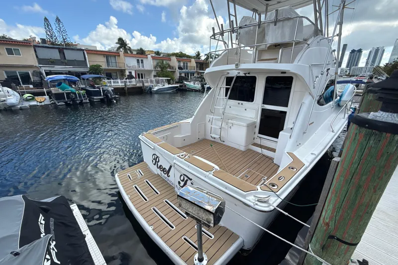  Yacht Photos Pics 2003 Riviera 37 Flybridge yacht docked in a marina, featuring spacious deck and elegant design.
