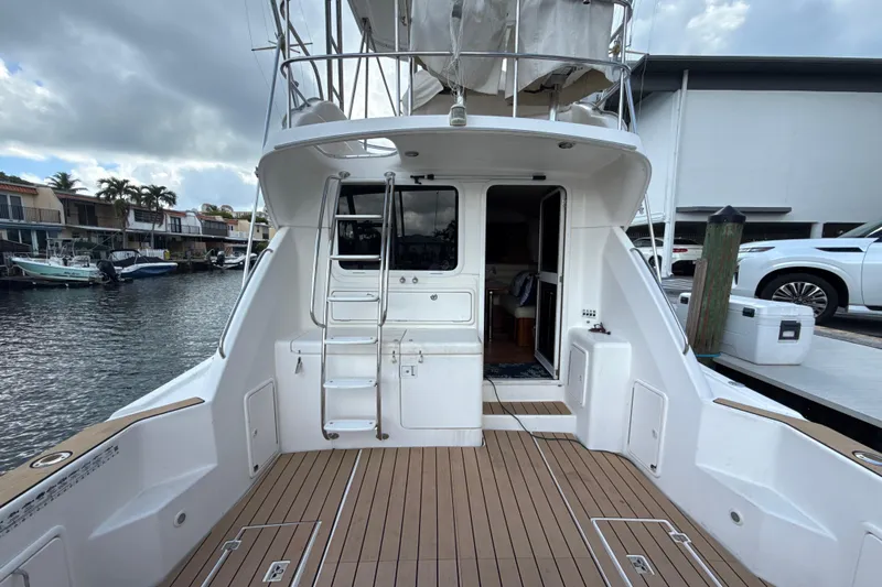  Yacht Photos Pics 2003 Riviera 37 Flybridge yacht docked, featuring spacious deck and ladder access.