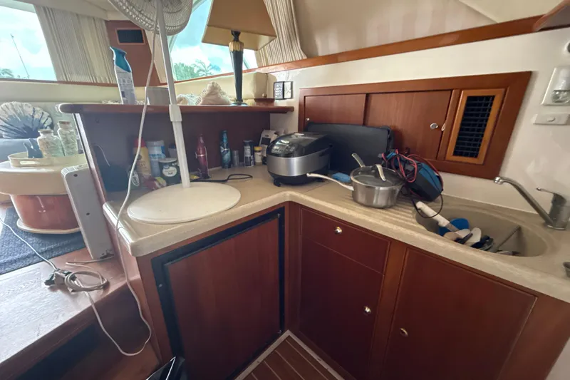  Yacht Photos Pics Kitchen area of 2003 Riviera 37 Flybridge yacht with appliances and wooden cabinetry.