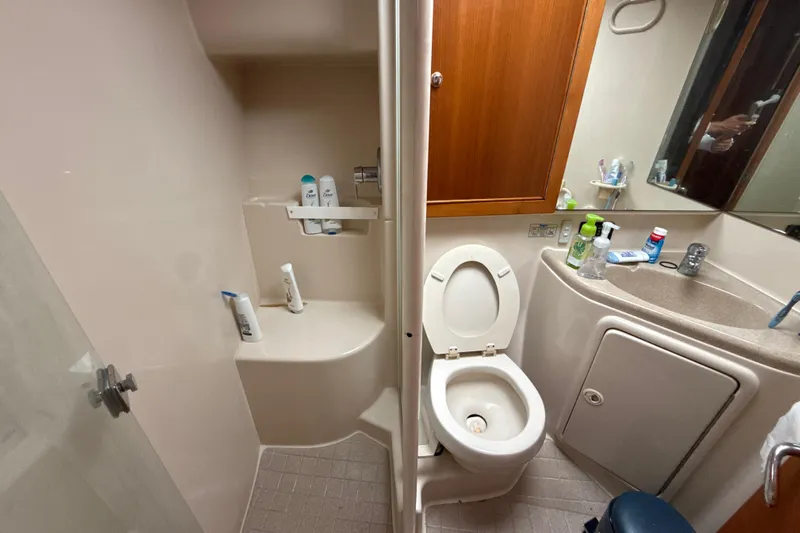  Yacht Photos Pics Bathroom interior of 2003 Riviera 37 Flybridge yacht with shower, toilet, and sink.