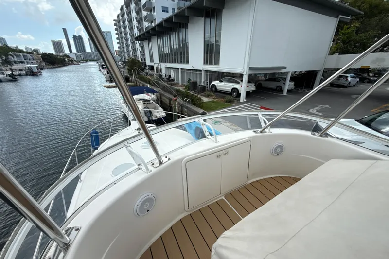  Yacht Photos Pics 2003 Riviera 37 Flybridge yacht docked near modern waterfront buildings.