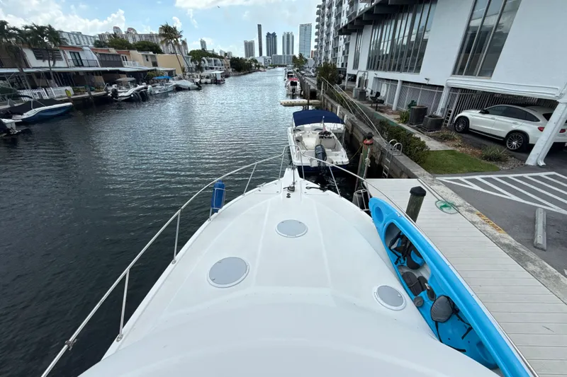  Yacht Photos Pics 2003 Riviera 37 Flybridge yacht docked in a scenic urban canal setting.