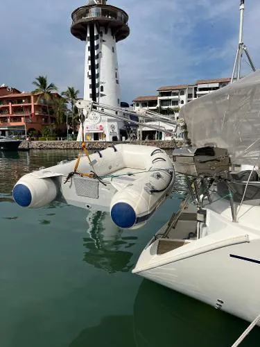  Yacht Photos Pics Beneteau Oceanis 510 sailboat docked near a lighthouse, with inflatable dinghy, 1991 model.