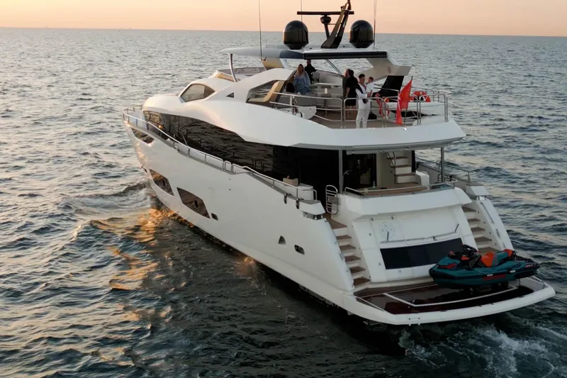  Yacht Photos Pics 2018 Sunseeker 95 Yacht cruising at sunset with people on deck.