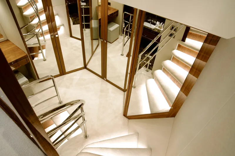  Yacht Photos Pics Luxurious interior of 2018 Sunseeker 95 Yacht with elegant staircase and mirrored walls.