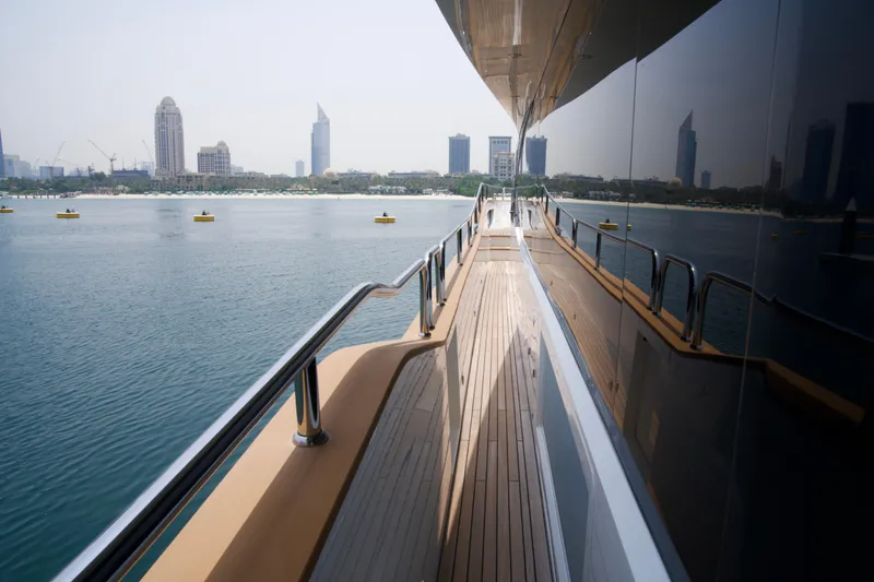 Yacht Photos Pics Side deck view of 2018 Sunseeker 95 Yacht with city skyline in background.
