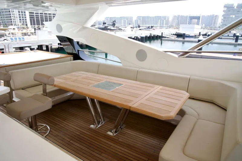  Yacht Photos Pics Luxurious seating area on 2018 Sunseeker 95 Yacht with wooden table and marina view.