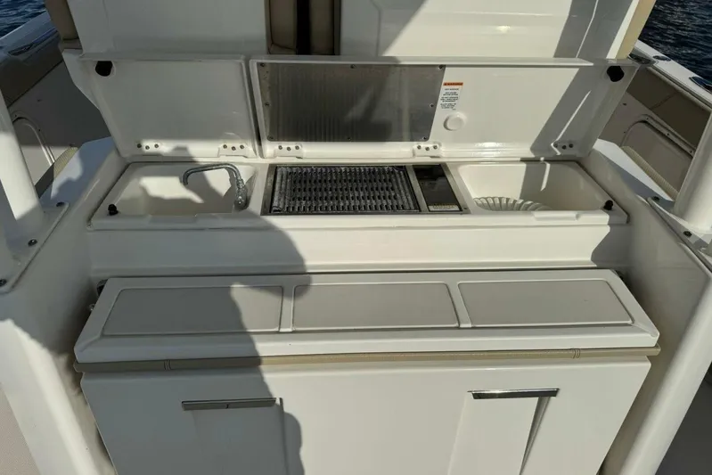  Yacht Photos Pics 2020 Pursuit S 328 Sport boat kitchen area with sink and grill.