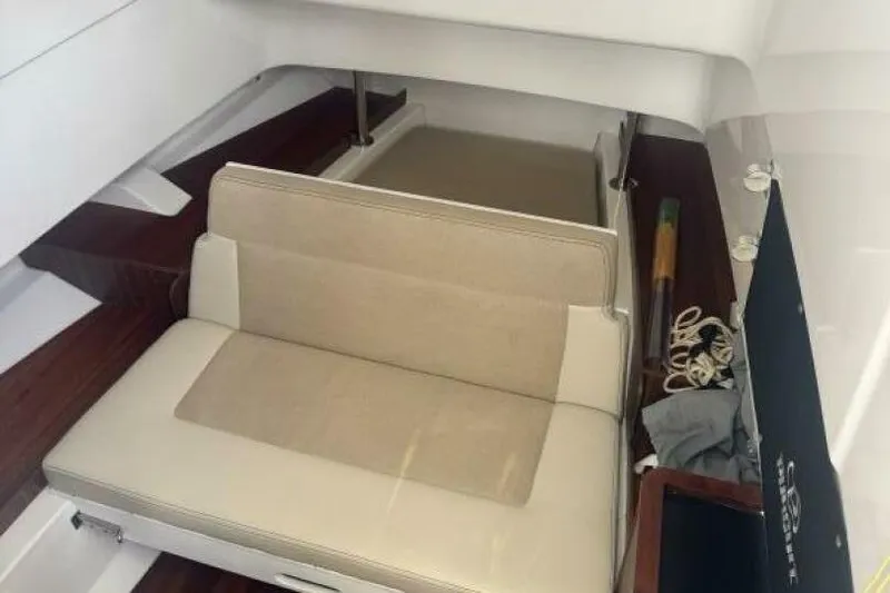 Yacht Photos Pics 2020 Pursuit S 328 Sport cabin interior with beige seating and wooden accents.