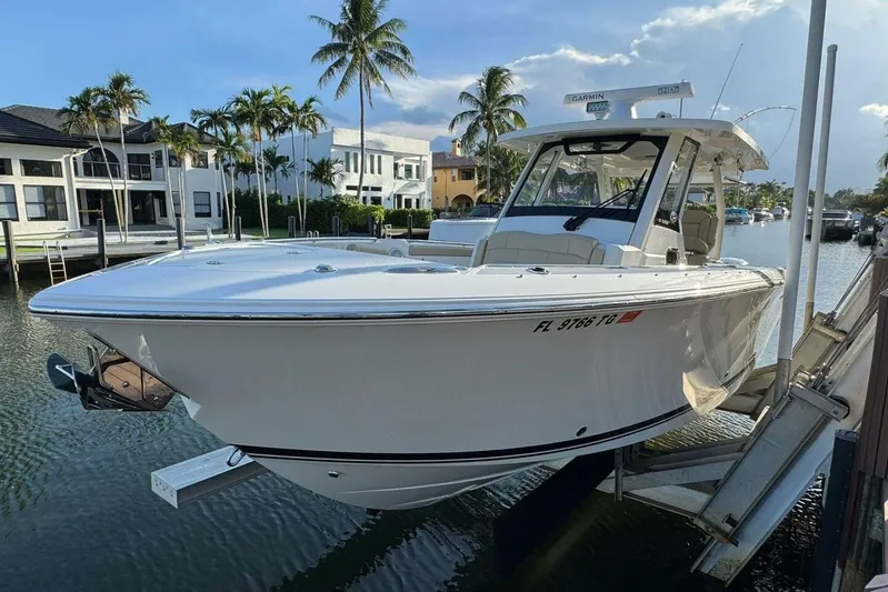  Yacht Photos Pics 2020 Pursuit S 328 Sport boat docked near waterfront homes and palm trees.