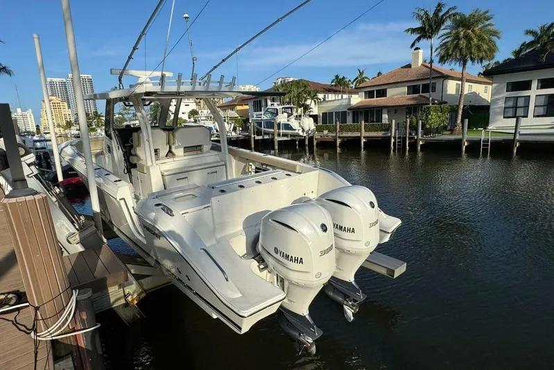  Yacht Photos Pics 2020 Pursuit S 328 Sport boat with twin Yamaha engines docked by waterfront homes.