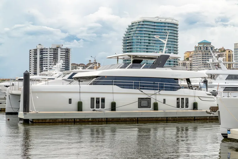 Fat Cat Yacht Photos Pics 2024 Sunreef 80 Power yacht docked in a marina with cityscape background.